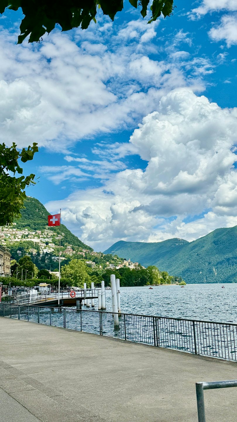 Schweizer Fahne weht an einer Promenade am Bergsee.